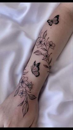 a woman's arm with flowers and butterflies on it