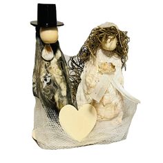 two figurines sitting next to each other on top of a white cloth bag