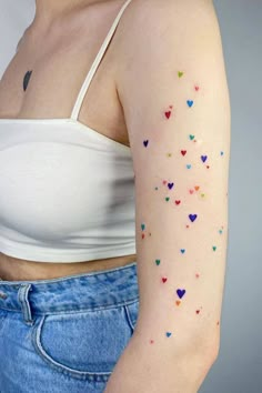 a woman's arm with colorful hearts on it