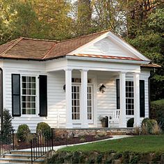 a white house with black shutters and a brown roof