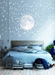 a bed room with a neatly made bed and stars on the wall next to it