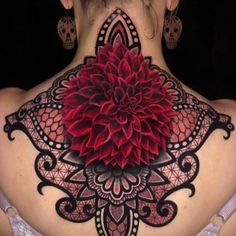 a woman's back with a large red flower on the top of her neck