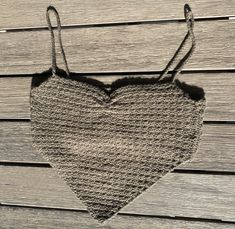 a knitted heart hanging on a wooden wall