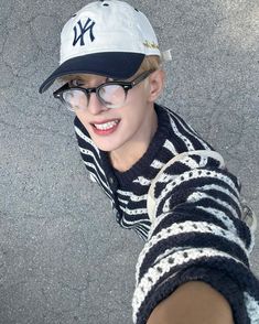 a young man wearing glasses and a new york yankees hat is looking up at the camera