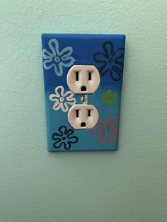 an electrical outlet is decorated with colorful flowers