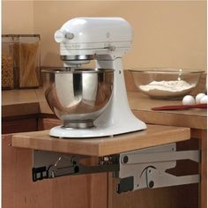 a white mixer sitting on top of a wooden counter