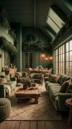 a living room filled with lots of furniture next to a large glass window covered in greenery