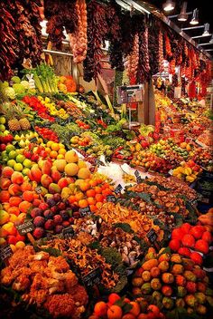 an outdoor market filled with lots of fruits and vegetables