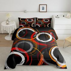 a bed covered in a black and red comforter