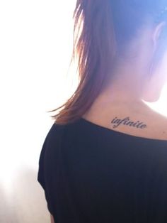 a woman with a small tattoo on her upper back neck and the word ignite written in cursive ink