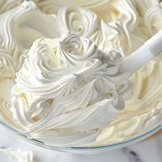 a large bowl filled with white frosting on top of a table