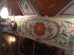 an artisticly painted ceiling in a restaurant with two lights on each side and one light hanging from the ceiling