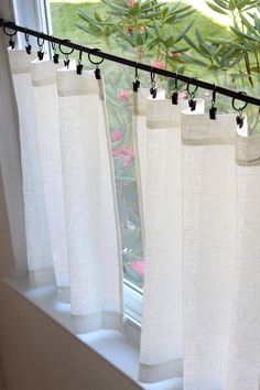 the curtains are hanging on the window sill in front of the flower potted plant