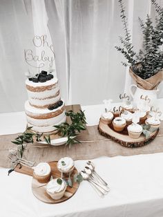 a table topped with three tiered cakes and cupcakes