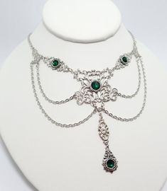 This is a new handmade necklace. It is made with light weight silver plated filigrees, accented with high quality EMERALD GREEN glass rhinestones and adorned with draping chains. Decorated portion is 5 1/2" wide and 3 1/4" tall in the center. Necklace is adjustable 15-18" with a lobster clasp and chain extender. If you would like a different length, please send us a message.Matching earrings and headpiece are listed in our store, also in a variety of other colors. Antique Silver Necklace, Celtic Goddess, Formal Jewelry, Medieval Jewelry, Choker Pendant, Head Jewelry, Magical Jewelry, Chain Extenders, Amethyst Purple