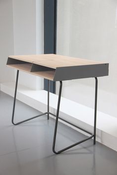 a wooden desk sitting in front of a window next to a white wall and floor