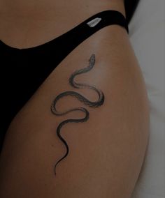 a woman's stomach with a snake tattoo on it