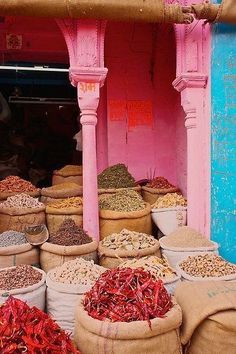 bags filled with various types of food sitting in front of a pink and blue building