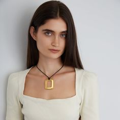 Elevate your jewelry collection with the Encanto necklace, showcasing a sophisticated square design. Handcrafted with 24K gold-plated metal alloy on a waxed cotton cord, it features an adjustable fastener that allows you to shorten or lengthen the necklace for your desired neckline. All jewelry is handcrafted and made to order in our New York City design studio. Please allow 7-14 business days for production from the order date. Measurements: 36" in length with a 2" L x 1 1/2" W pendant Formal Necklace, Beachy Necklace, Necklaces Silver, Dainty Choker, Square Pendant, Handcrafted Necklace, City Design, Classic Gold, Spring Trends