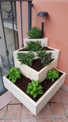 three wooden planters filled with plants on top of a tiled floor next to a pink wall