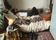 a man laying on top of a bed next to a plant