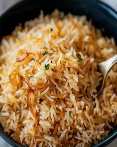 a bowl full of rice with a spoon in it