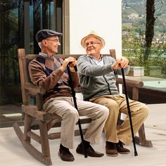 two elderly men sitting on a wooden rocking chair with canes in front of them