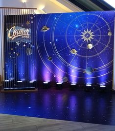 a stage set up for a show with lights and planets on the wall behind it