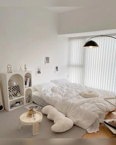 a white bed sitting in a bedroom next to a window