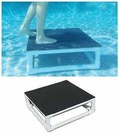 a person standing on top of a black and white table next to a swimming pool