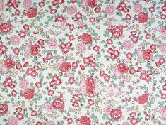 an old flowered fabric with red and pink flowers on it's white background