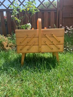 a wooden bench sitting on top of a lush green grass covered field next to a fence