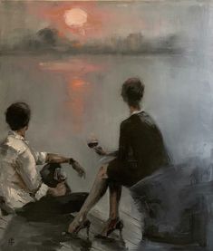 two people sitting on a bench near the water at sunset, one holding a glass of wine