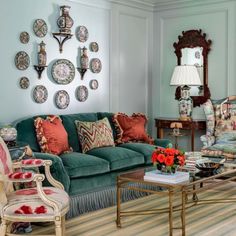 a living room filled with furniture and lots of plates hanging on the wall above it