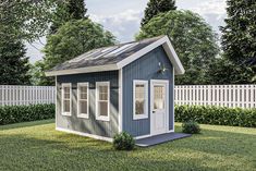 a small blue and white shed sitting in the grass