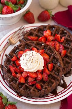 chocolate waffles topped with whipped cream and strawberries