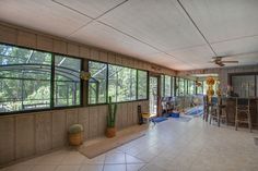 the inside of a house with large windows and tile flooring on both sides of the room