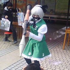 a woman dressed in green and white holding a baseball bat