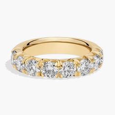 a yellow gold wedding ring with five stones on the side and two rows of diamonds in each