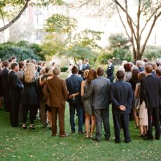 a group of people standing next to each other on top of a lush green field