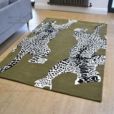 a green rug with black and white animal prints on it in front of a couch