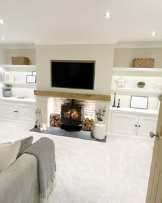 a living room filled with furniture and a flat screen tv mounted above a fire place