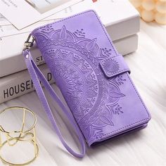 a purple purse sitting on top of a table next to a pair of glasses and a book