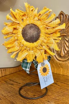 a sunflower with a tag attached to it sitting on a table