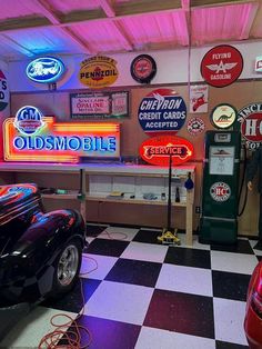 an old fashioned gas station with neon signs on the wall