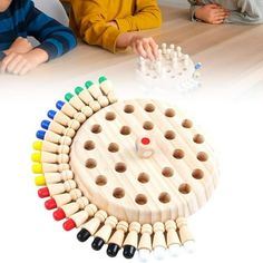 two children are sitting at a table playing with wooden pegs and an object that looks like a board game