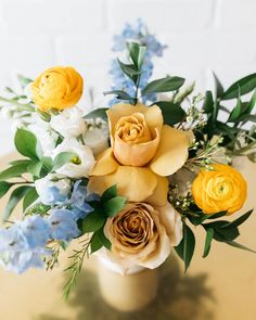 a vase filled with yellow and blue flowers