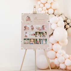 a baby's first year photo is displayed on a easel with balloons in the background