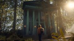 a person standing in front of a building surrounded by trees