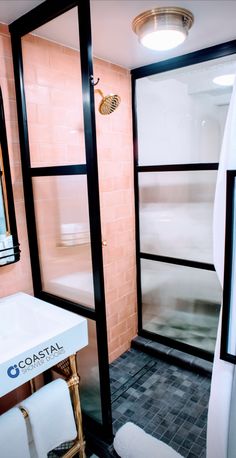 a bathroom with pink walls and black trim